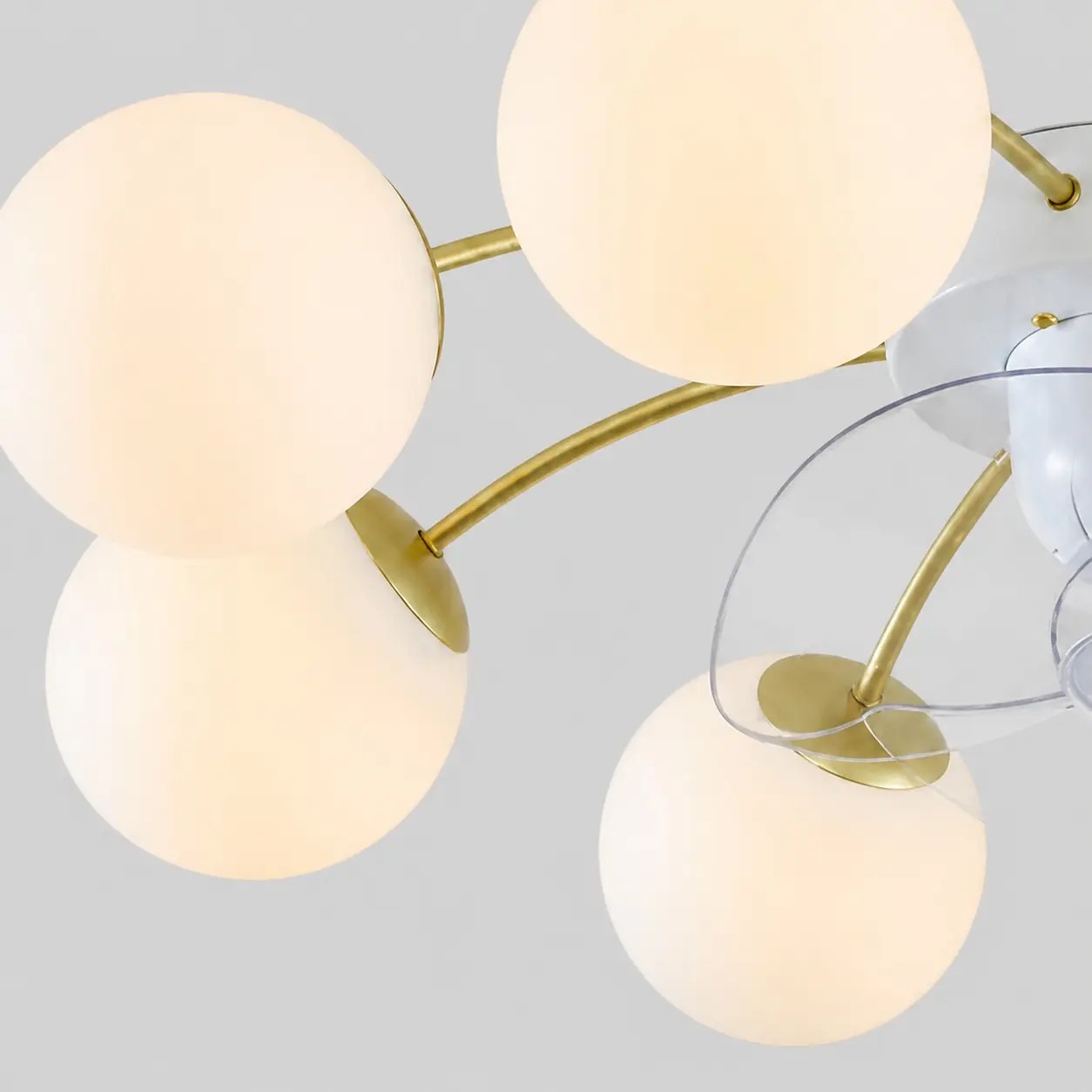 Primer plano de los globos de cristal blanco y los brazos de tono dorado.