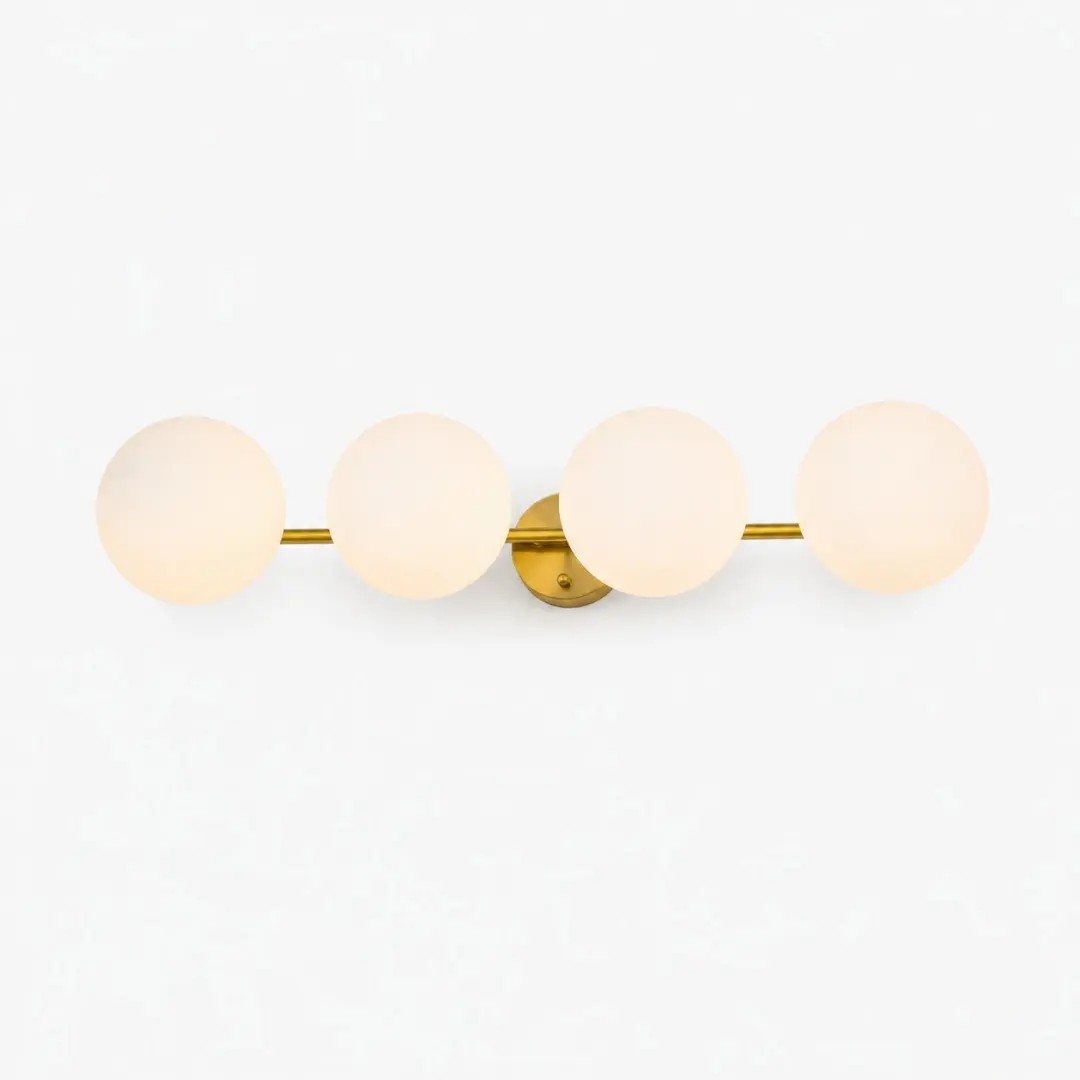 Lámpara de tocador dorada de cuatro luces con globos de vidrio opalino.
