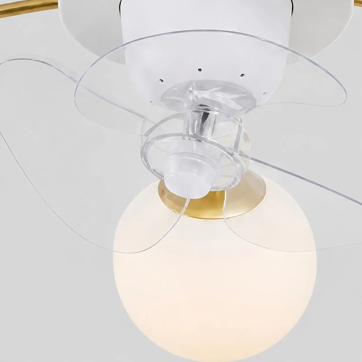 Primer plano de las aspas transparentes del ventilador y las esferas de cristal blanco.