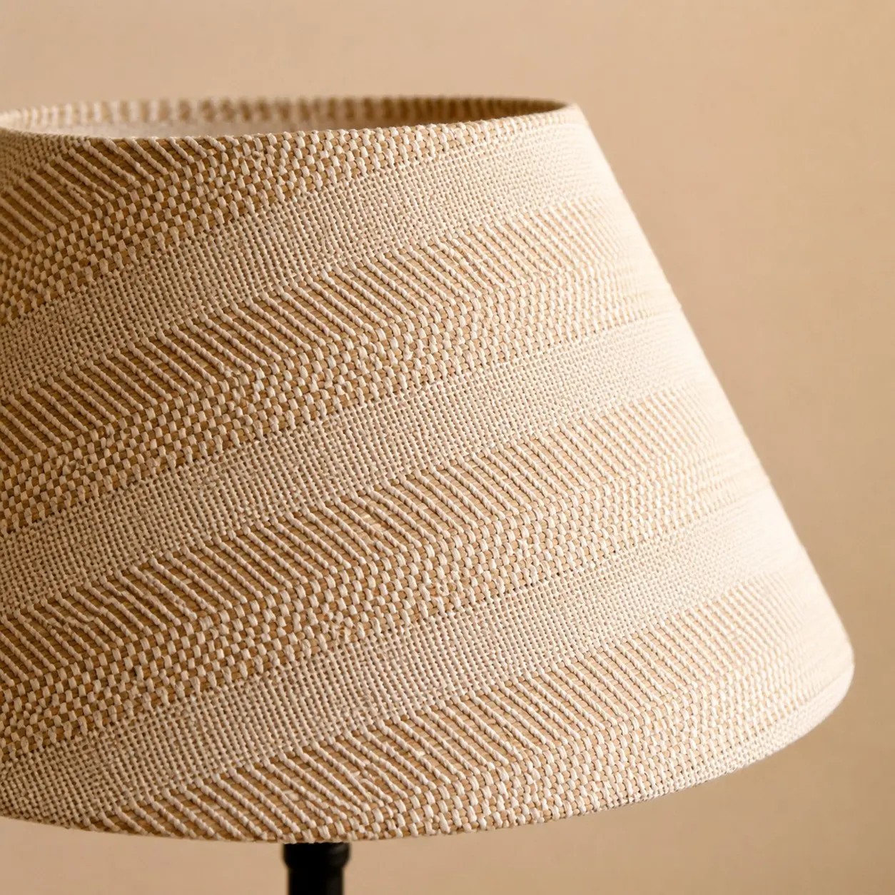 Detailopname van de beige rasterstof van de lampenkap.