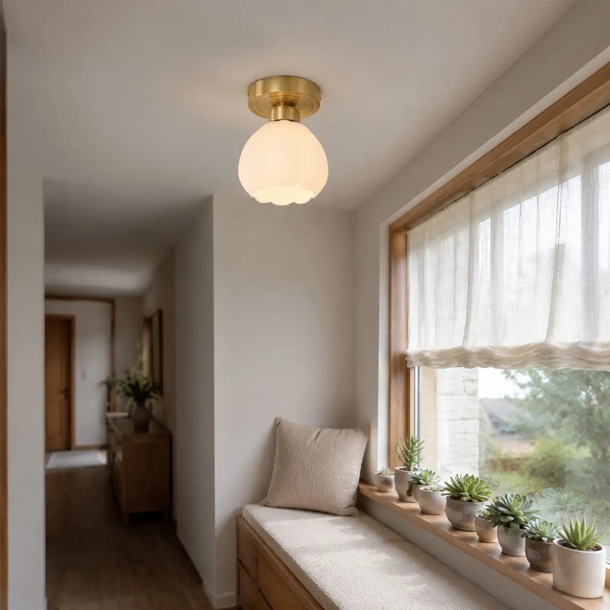 Plafondlamp van melkglas in de vorm van een bloem boven een vensterbank.