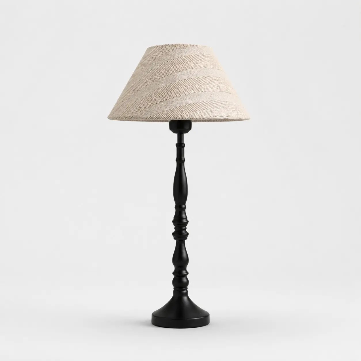 Beige tafellamp van rasterstof met zwarte ijzeren voet.