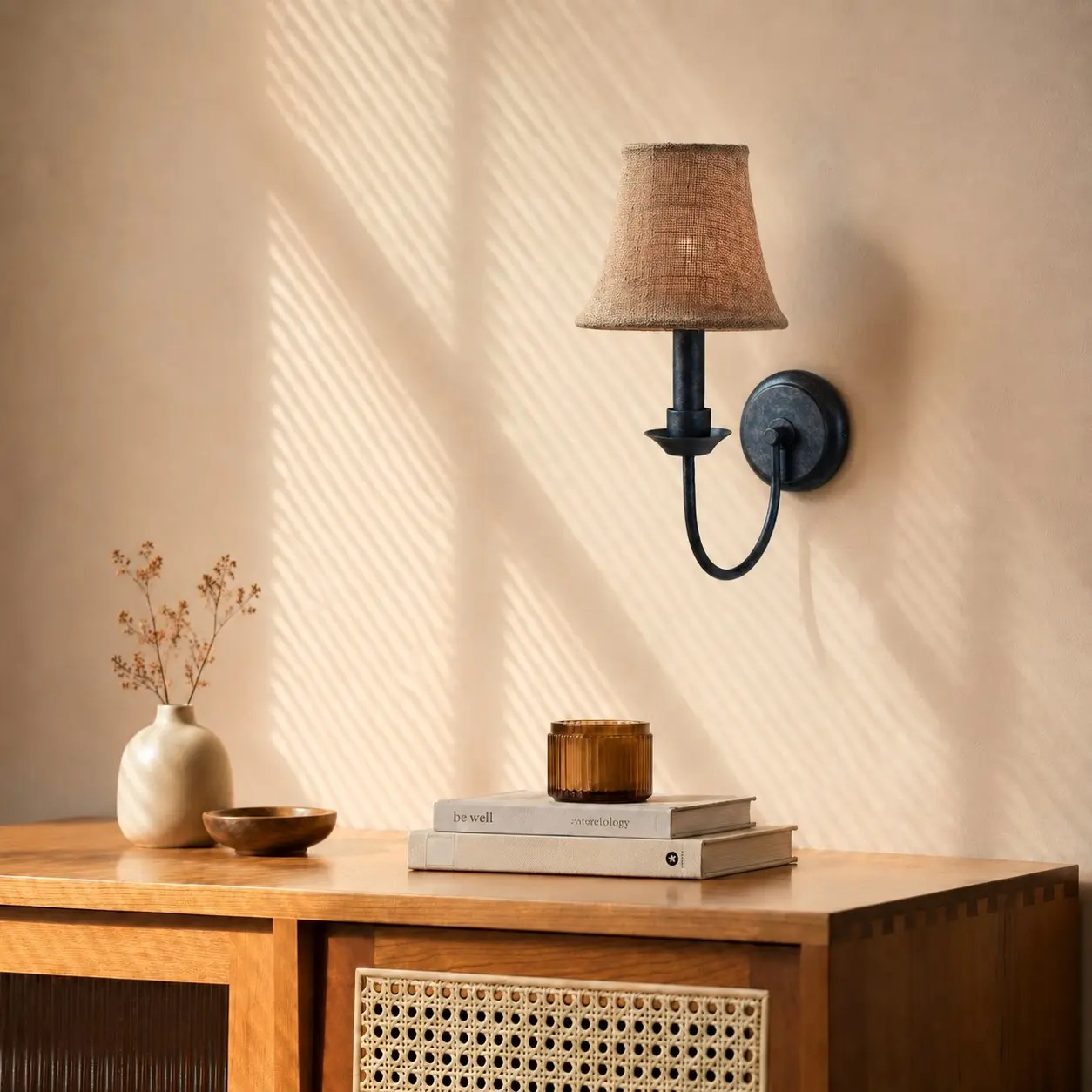 Aplique de pared de tela sobre una cálida consola de madera.