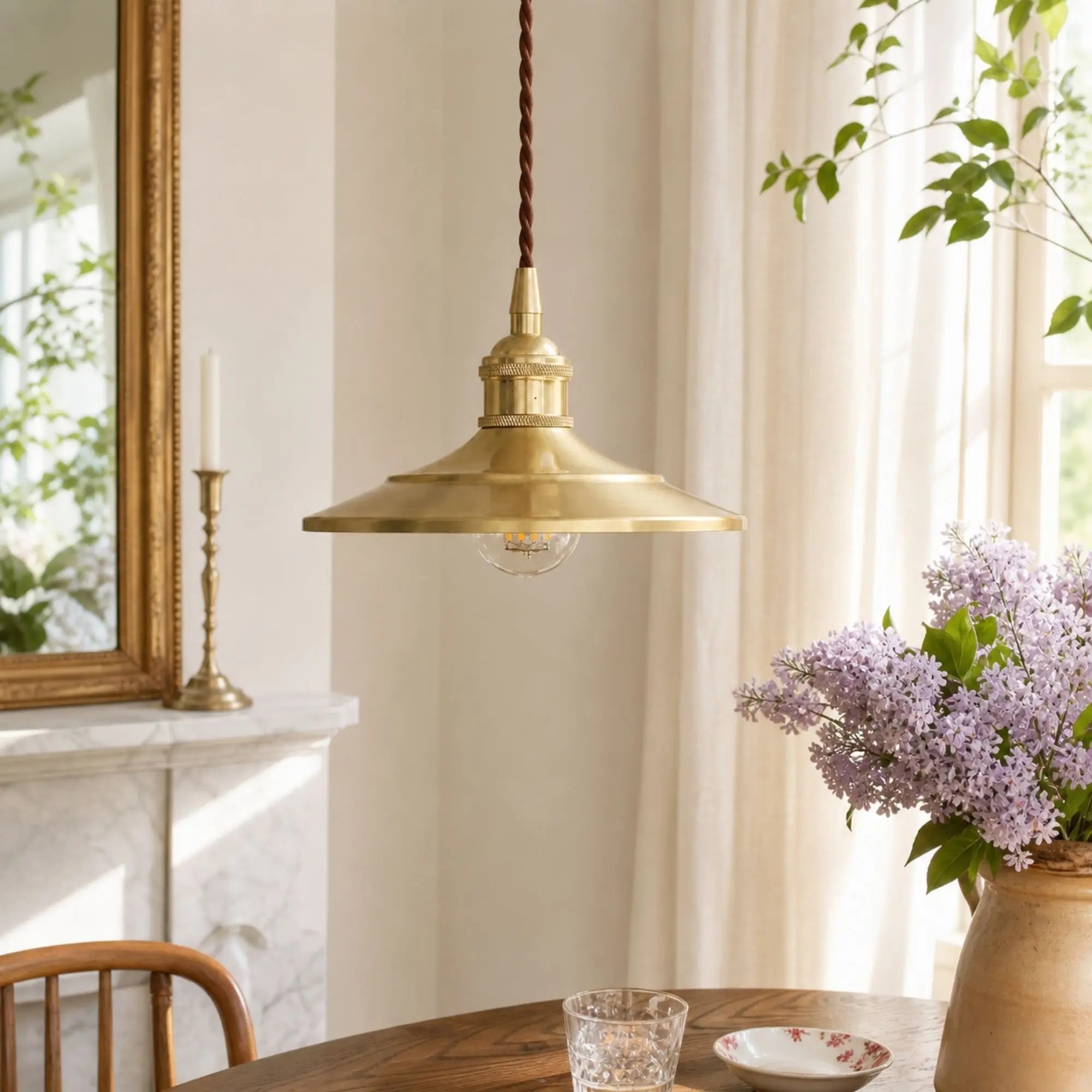 Polished brass pendant light in a bright dining room